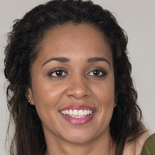 Joyful black adult female with long  brown hair and brown eyes