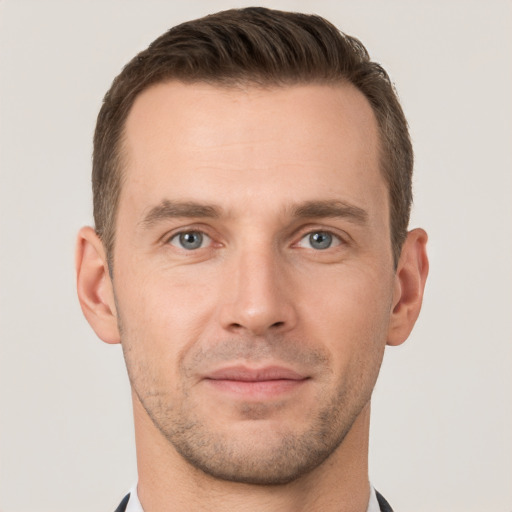 Joyful white young-adult male with short  brown hair and grey eyes