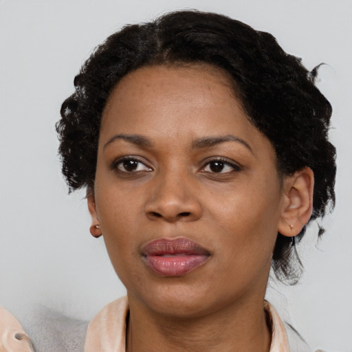 Joyful black adult female with short  black hair and brown eyes