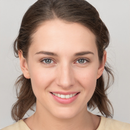 Joyful white young-adult female with medium  brown hair and grey eyes