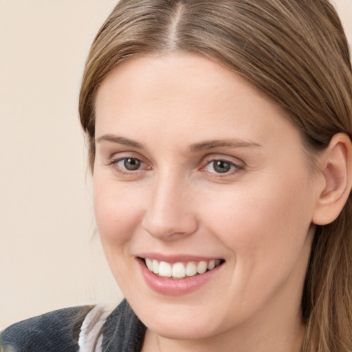 Joyful white young-adult female with long  brown hair and brown eyes