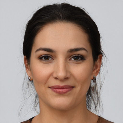 Joyful latino young-adult female with medium  brown hair and brown eyes