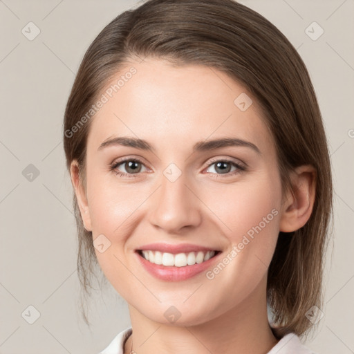 Joyful white young-adult female with medium  brown hair and grey eyes