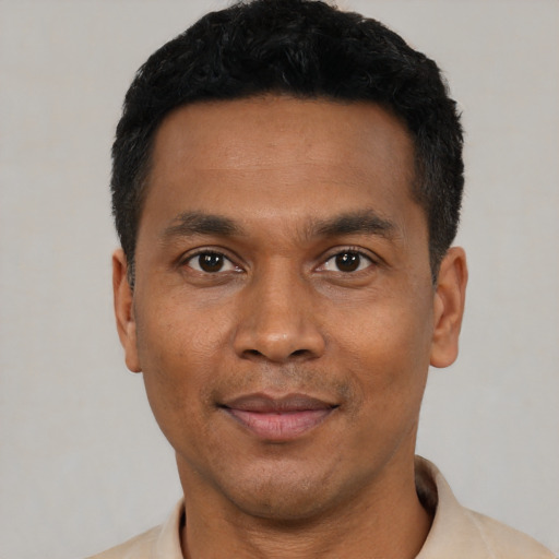 Joyful black young-adult male with short  black hair and brown eyes