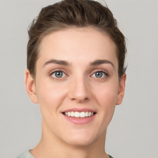 Joyful white young-adult female with short  brown hair and grey eyes