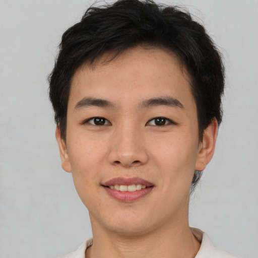 Joyful asian young-adult male with short  brown hair and brown eyes