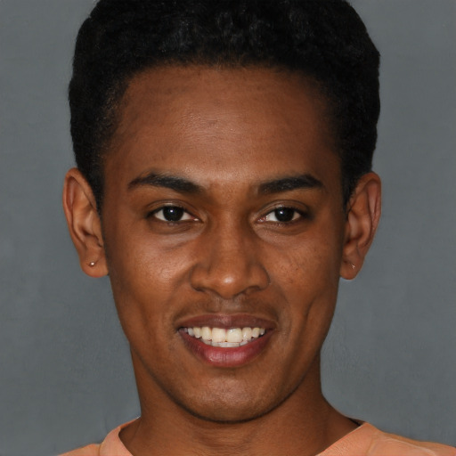 Joyful black young-adult male with short  brown hair and brown eyes