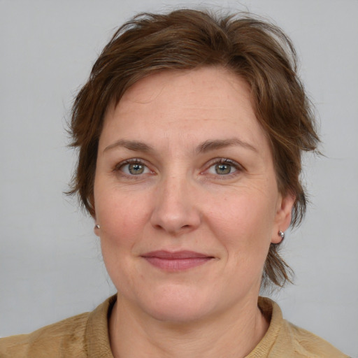 Joyful white adult female with medium  brown hair and blue eyes