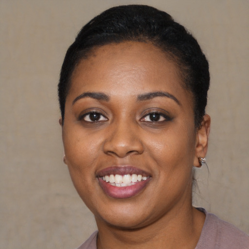 Joyful black young-adult female with short  black hair and brown eyes