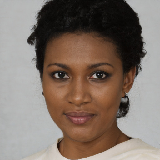 Joyful black young-adult female with short  black hair and brown eyes