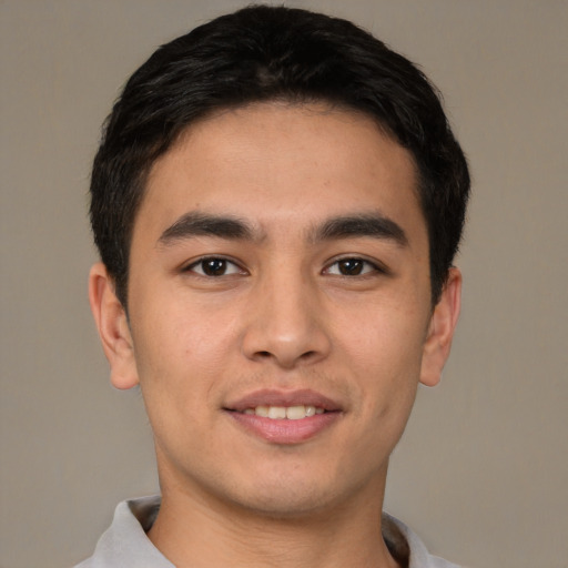 Joyful latino young-adult male with short  brown hair and brown eyes