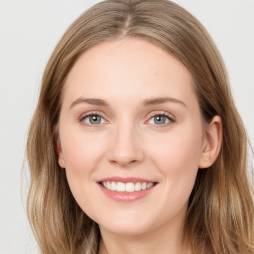 Joyful white young-adult female with long  brown hair and grey eyes