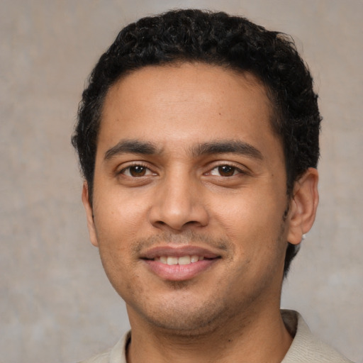 Joyful latino young-adult male with short  black hair and brown eyes