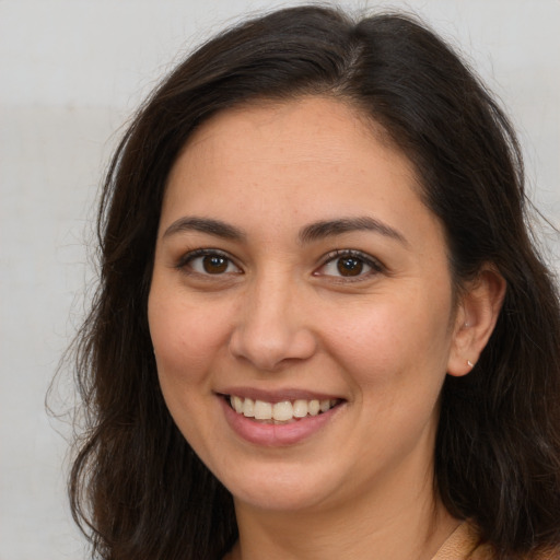 Joyful white young-adult female with long  brown hair and brown eyes
