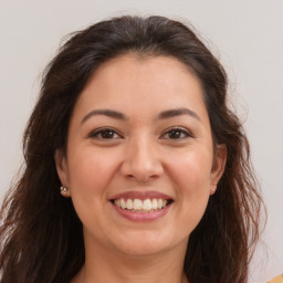 Joyful white young-adult female with long  brown hair and brown eyes