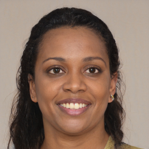 Joyful black young-adult female with long  brown hair and brown eyes
