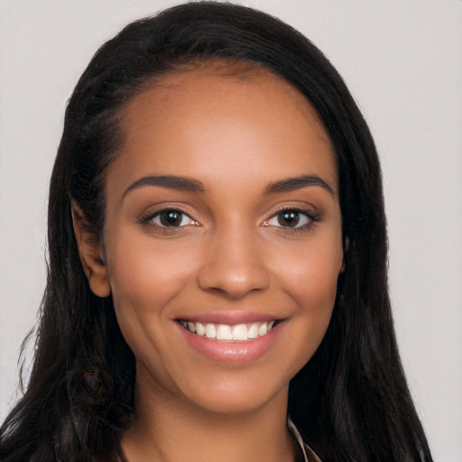 Joyful latino young-adult female with long  black hair and brown eyes