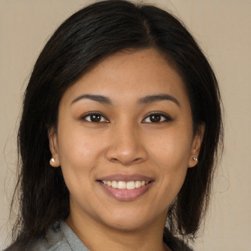 Joyful latino young-adult female with medium  brown hair and brown eyes