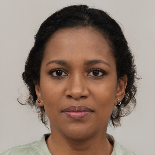 Joyful black young-adult female with medium  brown hair and brown eyes