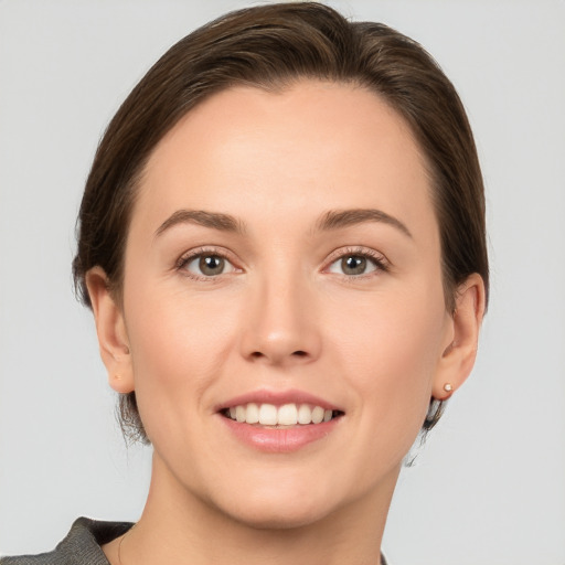 Joyful white young-adult female with short  brown hair and grey eyes