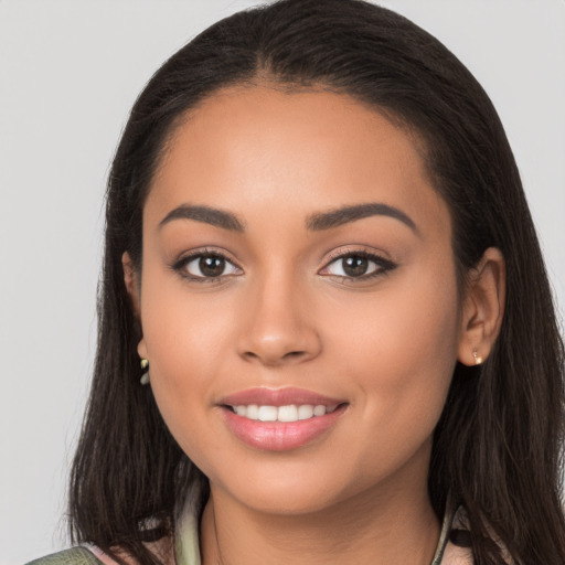 Joyful latino young-adult female with long  brown hair and brown eyes