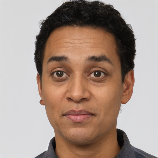 Joyful latino adult male with short  black hair and brown eyes