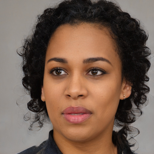 Joyful black young-adult female with long  black hair and brown eyes