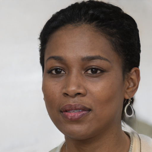 Joyful black young-adult female with short  black hair and brown eyes