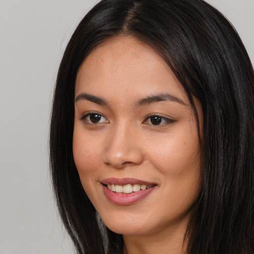 Joyful asian young-adult female with long  black hair and brown eyes