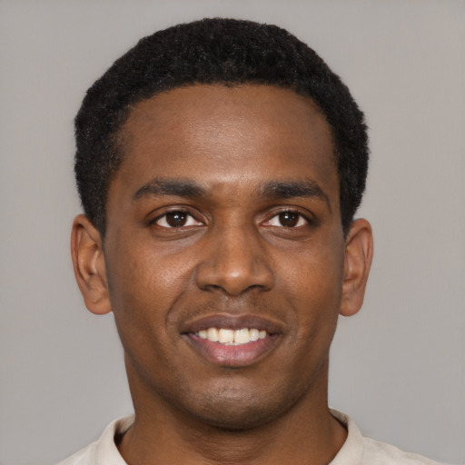Joyful black young-adult male with short  black hair and brown eyes