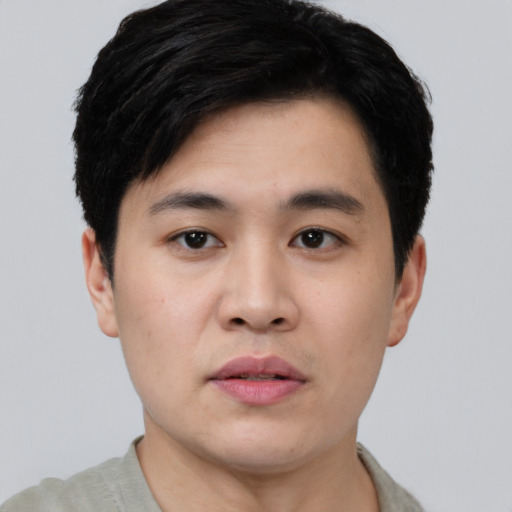 Joyful asian young-adult male with short  black hair and brown eyes