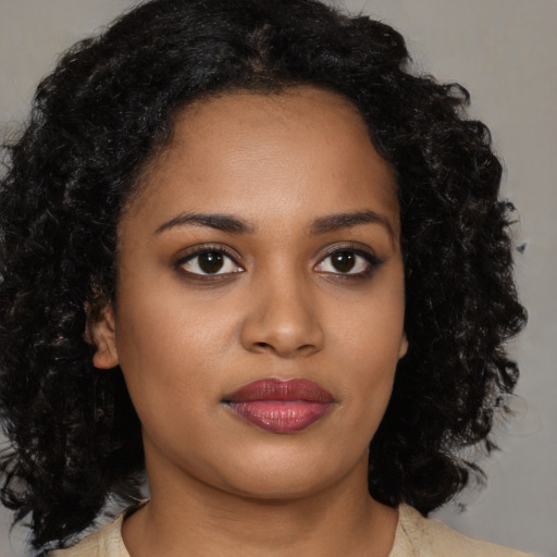 Joyful black young-adult female with medium  brown hair and brown eyes