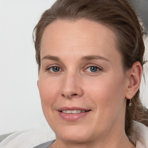 Joyful white adult female with medium  brown hair and grey eyes