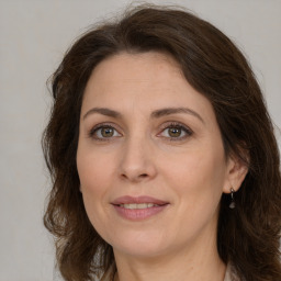 Joyful white adult female with medium  brown hair and green eyes