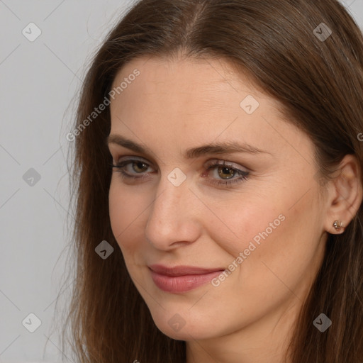 Joyful white young-adult female with long  brown hair and brown eyes