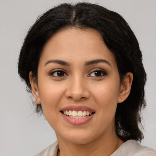 Joyful latino young-adult female with medium  brown hair and brown eyes