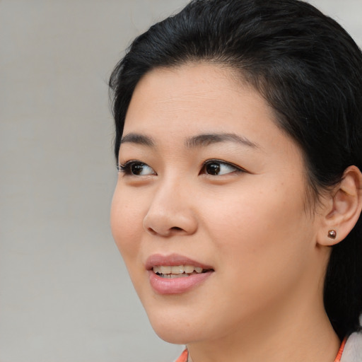Joyful asian young-adult female with medium  black hair and brown eyes