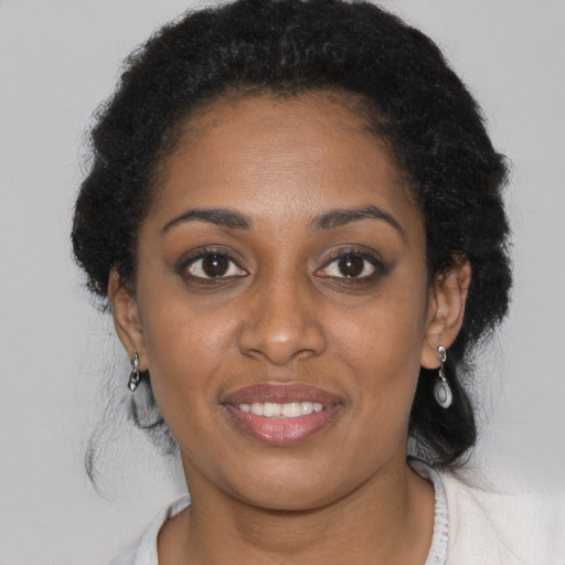 Joyful black young-adult female with short  black hair and brown eyes