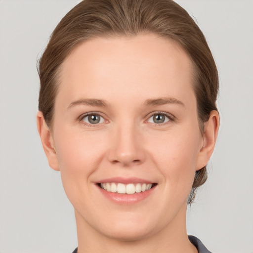 Joyful white young-adult female with short  brown hair and grey eyes