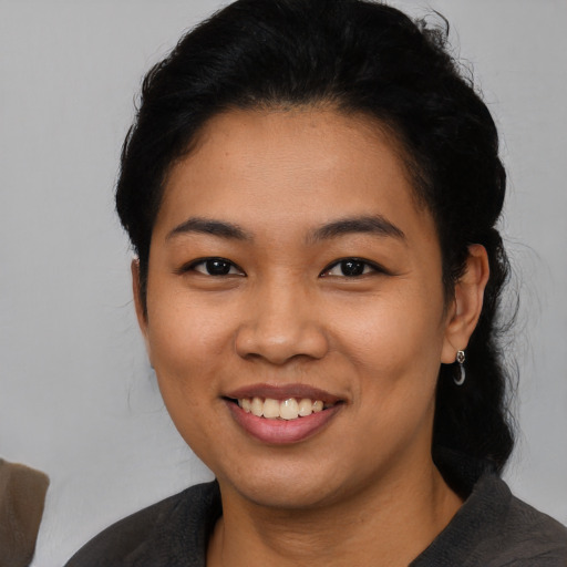 Joyful latino young-adult female with medium  black hair and brown eyes