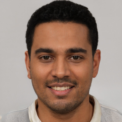 Joyful latino young-adult male with short  black hair and brown eyes