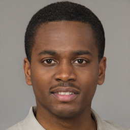 Joyful black young-adult male with short  brown hair and brown eyes