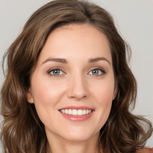 Joyful white young-adult female with long  brown hair and green eyes