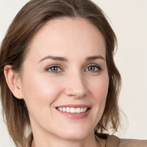 Joyful white young-adult female with medium  brown hair and grey eyes