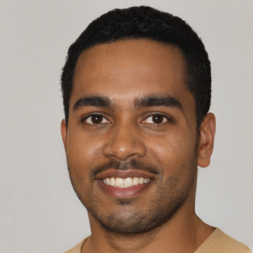 Joyful black young-adult male with short  black hair and brown eyes