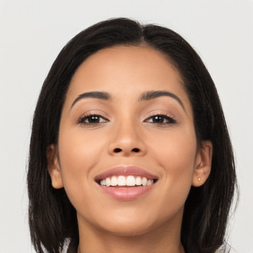 Joyful latino young-adult female with long  brown hair and brown eyes