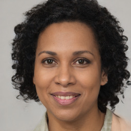 Joyful black adult female with long  brown hair and brown eyes