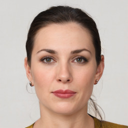 Joyful white young-adult female with medium  brown hair and grey eyes