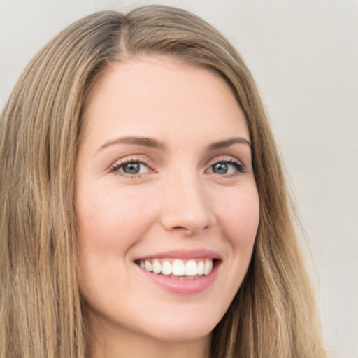 Joyful white young-adult female with long  brown hair and green eyes