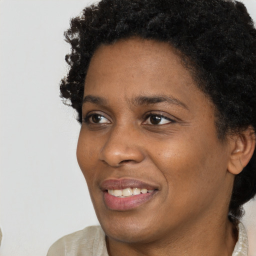 Joyful black young-adult female with short  brown hair and brown eyes